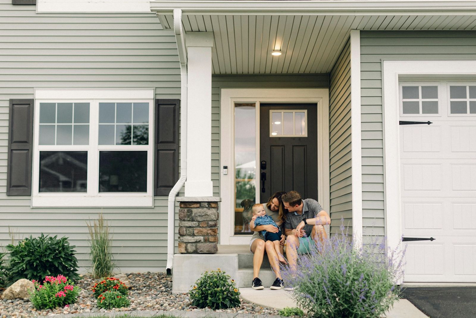 A couple sitting together on the front steps of their home