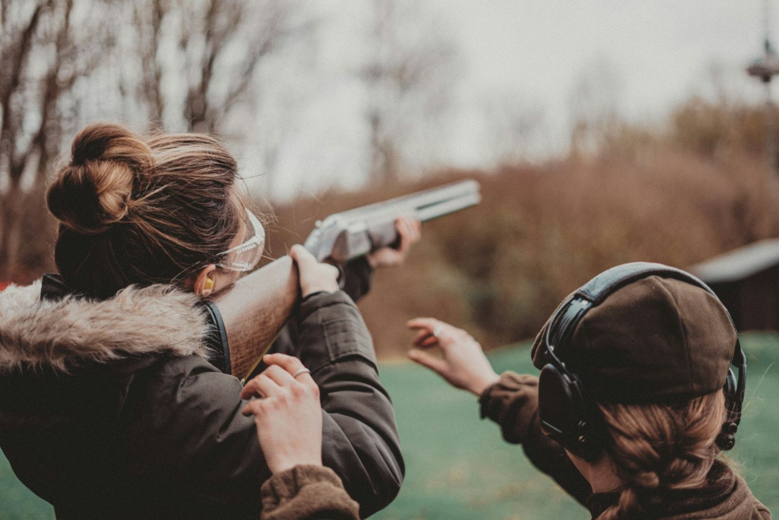 Two women in ear protection practicing at an outdoor range